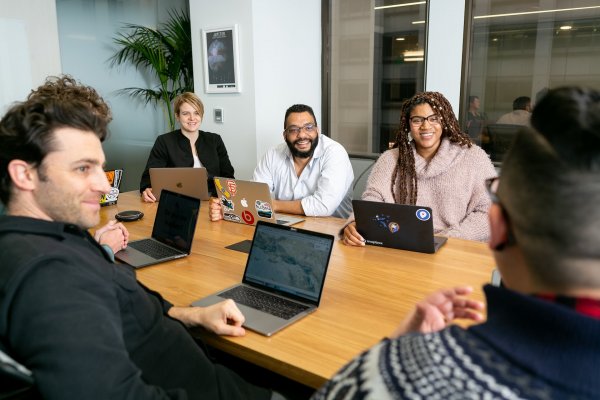 team meeting in an office with laptops out